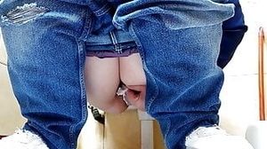 Hot MILF in jeans pissing in a public restroom